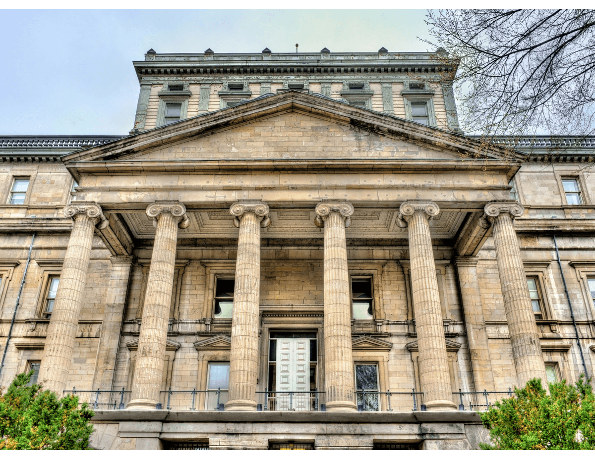 Façade imposante d'un palais de justice en pierre avec colonnes classiques.