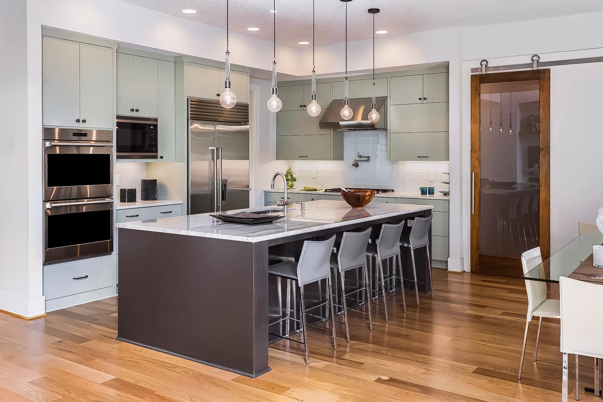 Cuisine moderne avec îlot central, comptoir en marbre et électroménagers en acier inoxydable.
