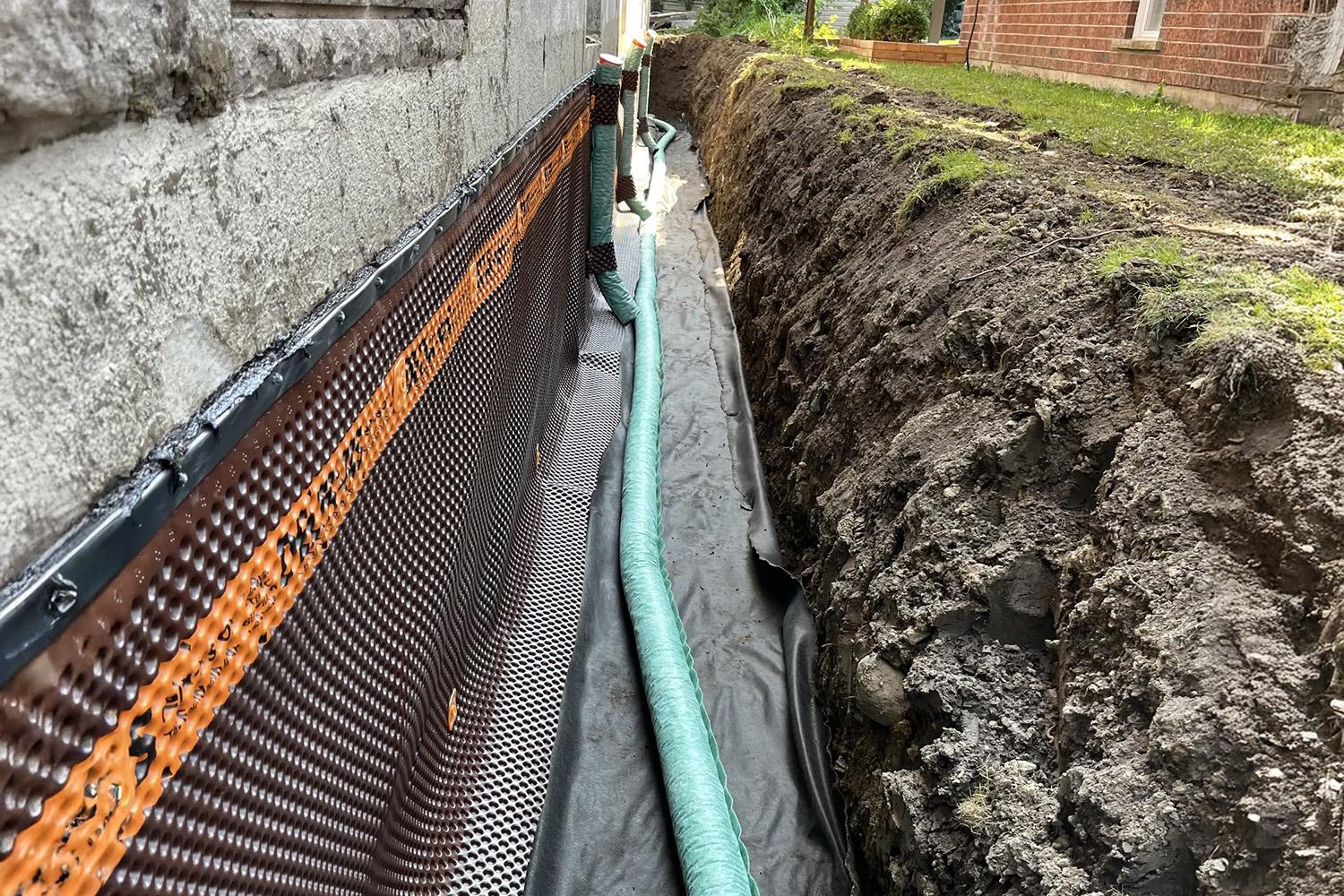&nbsp;Installation d’un drain français avec membrane d’étanchéité le long des fondations d’une maison.