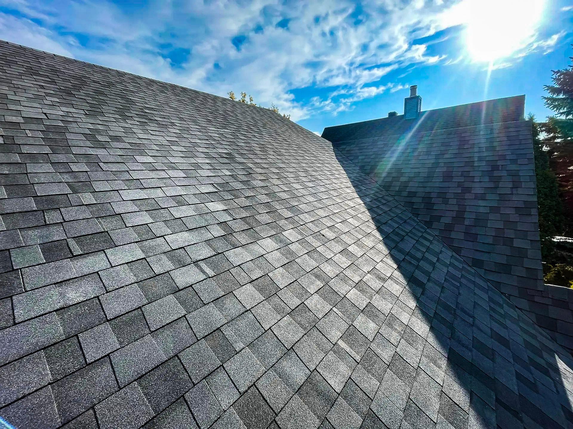 Toiture en bardeaux moderne avec un éclairage naturel sous un ciel ensoleillé.